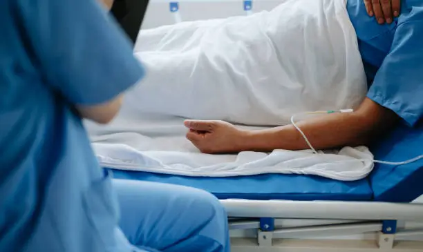 A person lying on a hospital bed