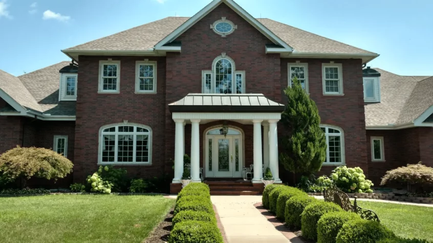 A brick house with columns and a walkway