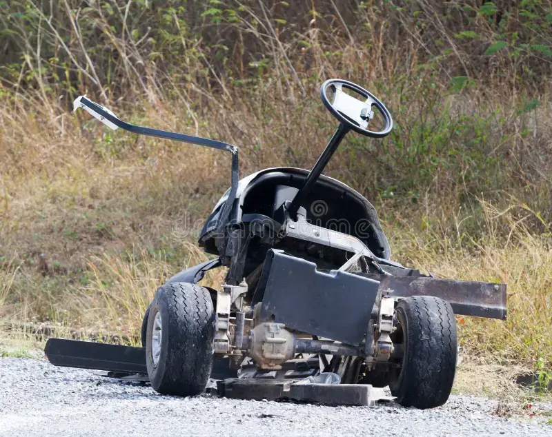 a broken golf cart on a gravel road