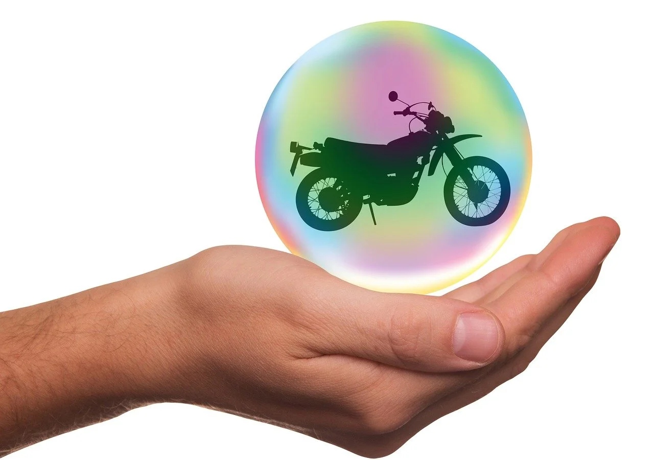 a hand holding a bubble with a motorcycle silhouette