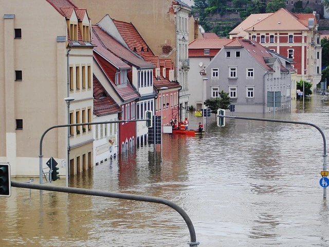 a flooded street with buildings and a boat
